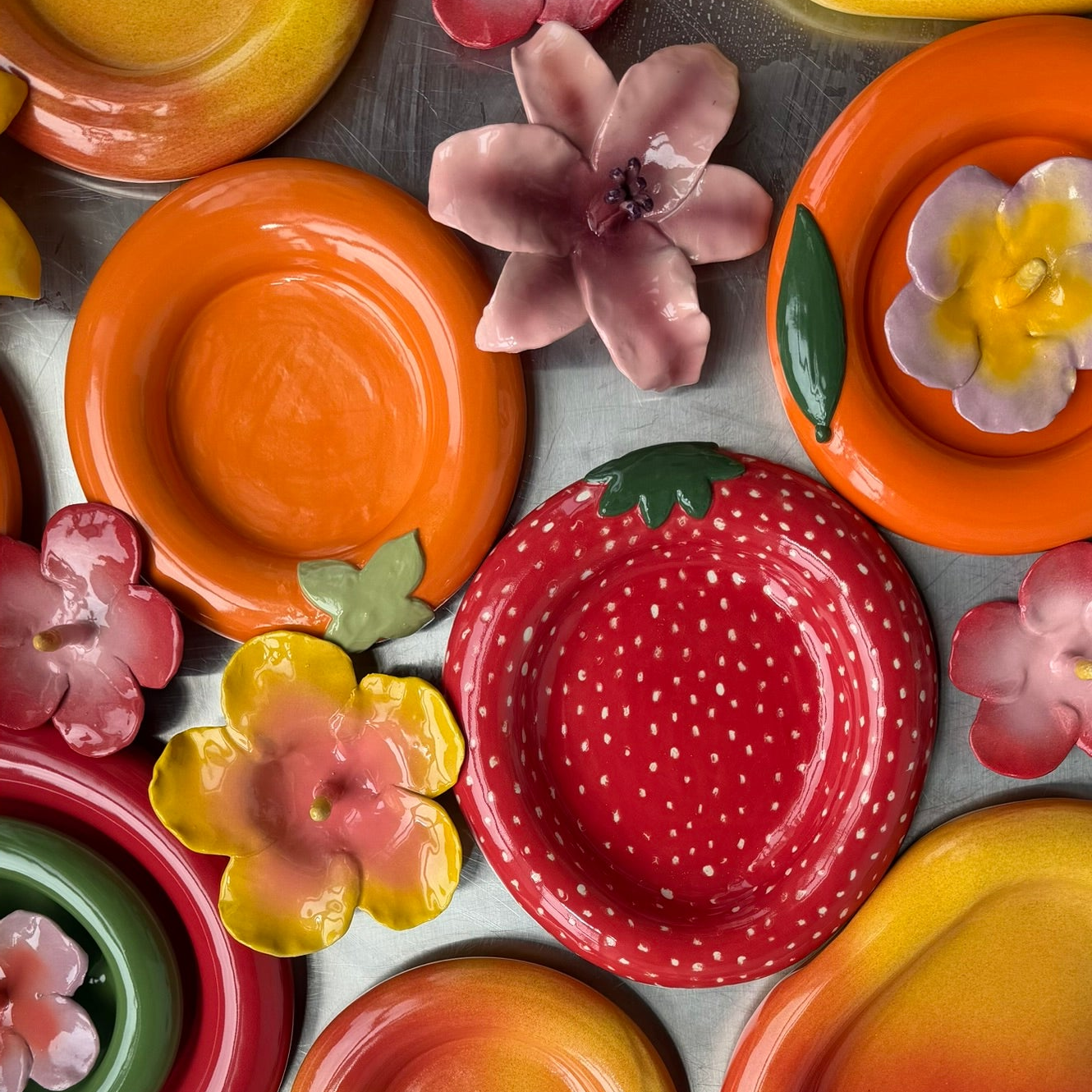 Colorful ceramic plates with floral designs on a metal surface