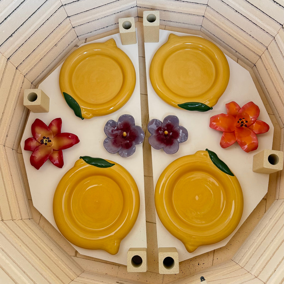 Decorative item with yellow circular plates and colorful flowers in the kiln